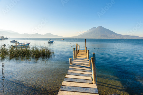 Wooden pier at Lake Atitlan on the shore at Panajachel  Guatemala.  With beautiful landscape scenery of volcanoes Toliman  Atitlan and San Pedro in the background.