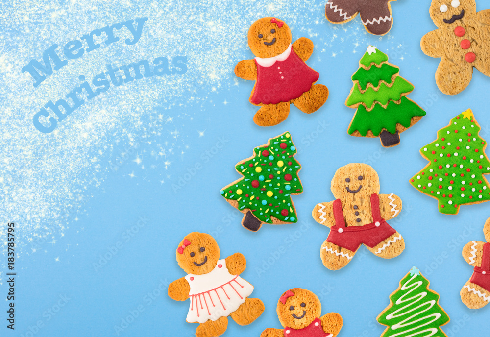 Christmas cookies of different shapes and sizes with a festive decor on a blue background. Holiday Poster concept. Empty place for a postural inscription