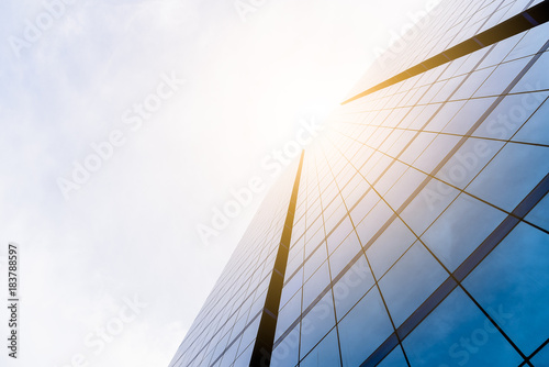 Bottom view of office building window close up with sunrise, reflection and perspective.