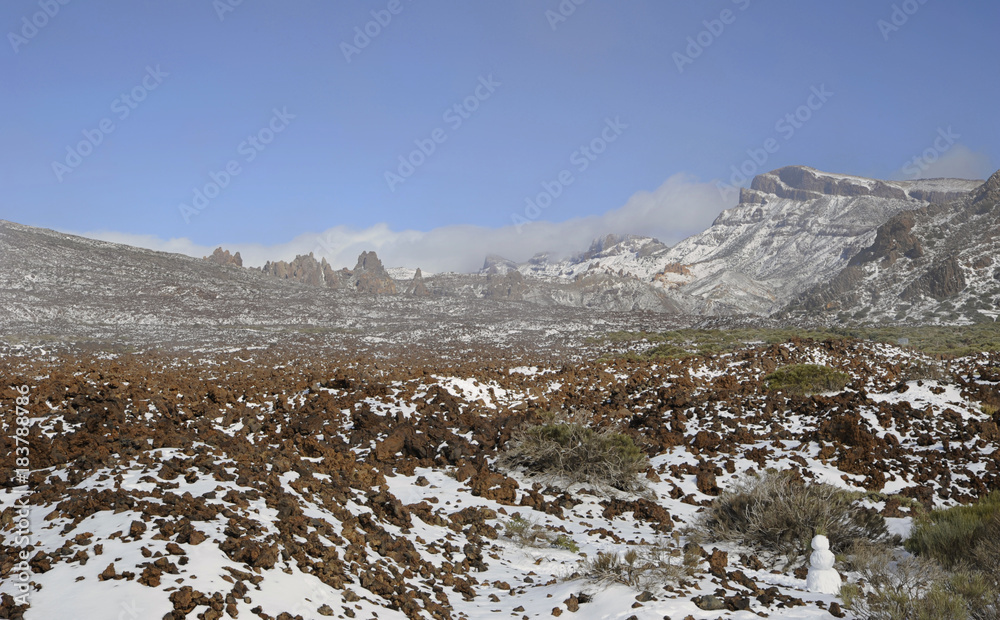 Clear day with thin, low clouds at horizon, vistas towards Llano de Ucanca, covered in snow, at the high altitude of Las Canadas del Teide, Teide National Park, Tenerife, Canary Islands, Spain