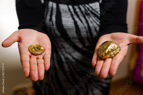 Gold nuggets with a bitcoin in the hands of the miner mining golden bitcoins