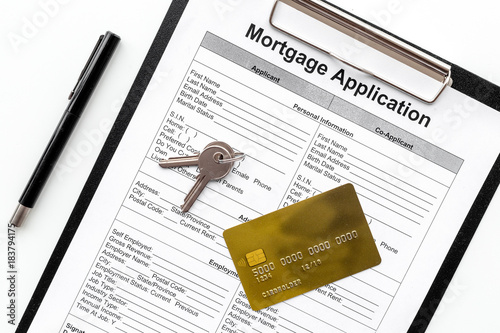 Mortgage application near bank card and apartment keys on white background top view