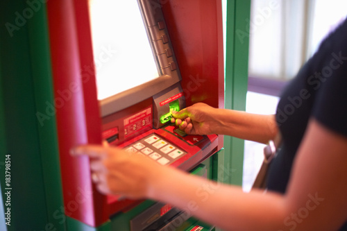 Cropped view of woman withdrawing money from cash machine