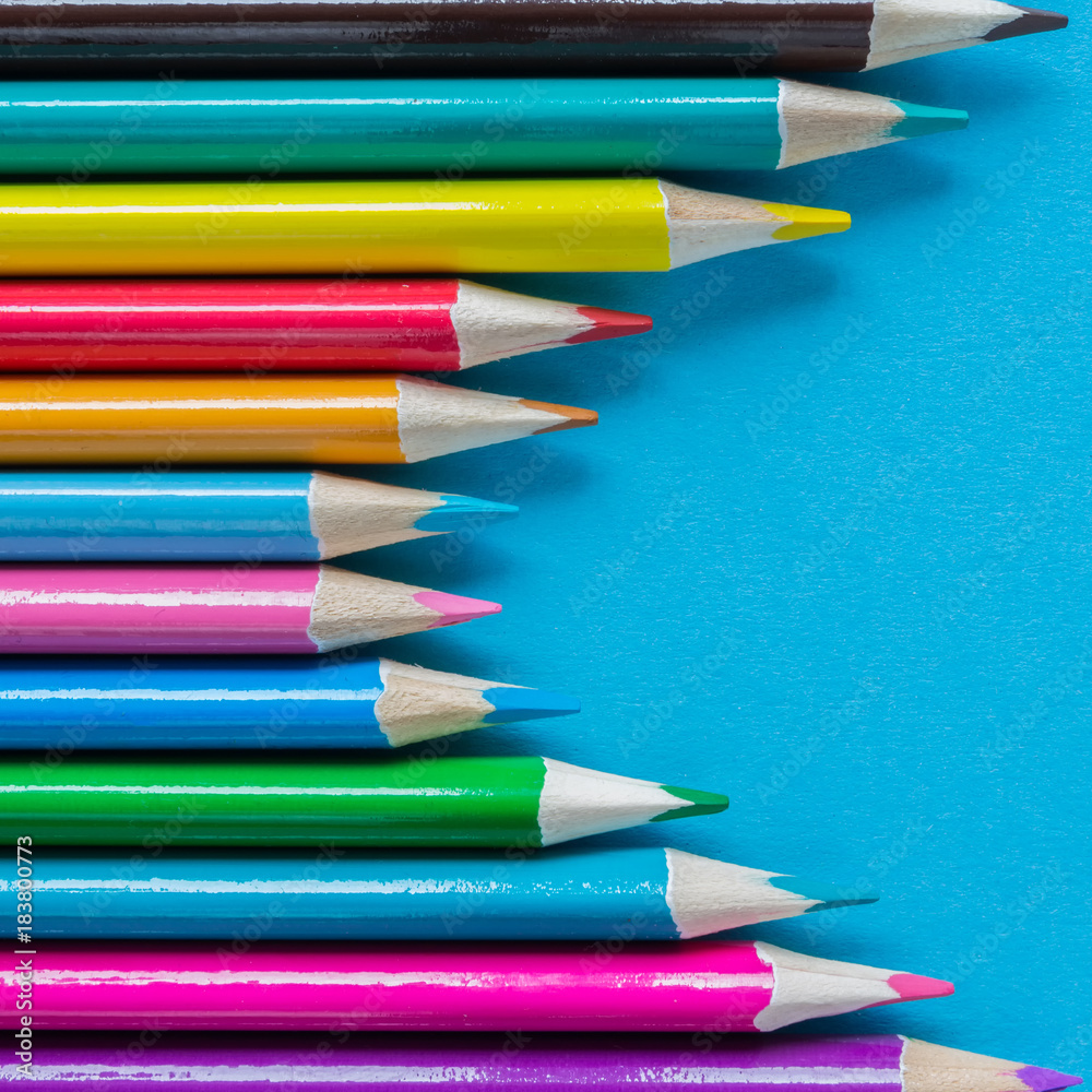 Multicolored pencils on a blue background with a large frame Multicolored pencils on a blue background with a large frame