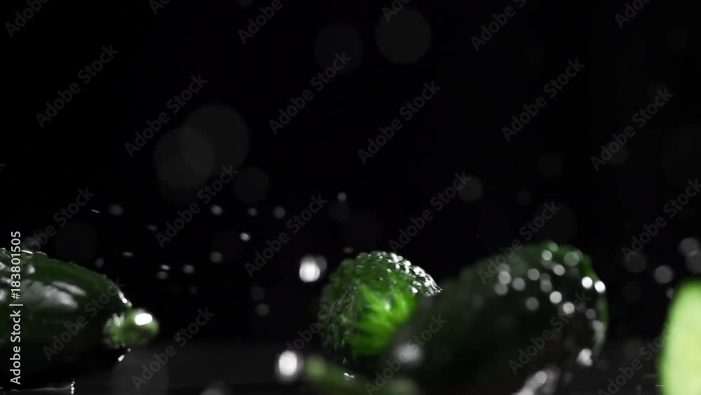 Green cucumbers fall and split into halves in slow motion, food in super slow motion, 240 frames per second, fresh vegetables Green cucumbers fall and split into halves in slow motion, food in super slow motion, 240 frames per second, fresh vegetables