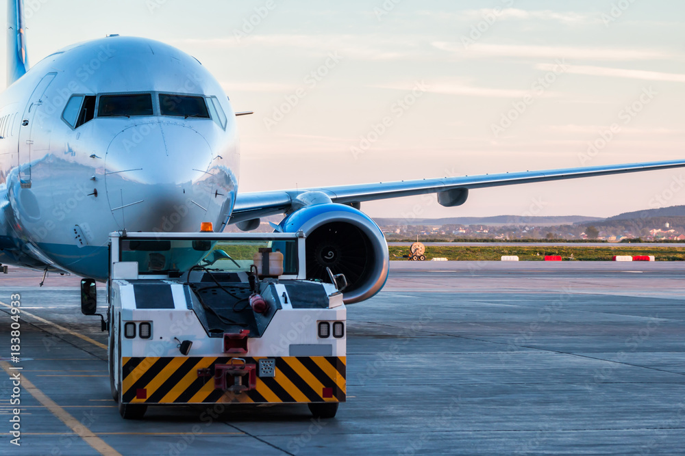Tow tractor is pushing the passenger airplane Tow tractor is pushing the passenger airplane