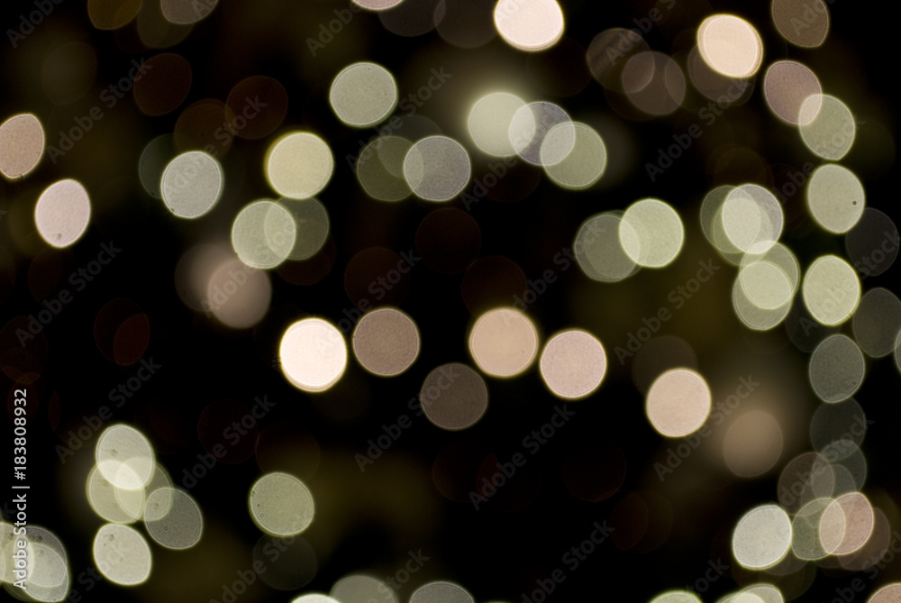 christmas background: blurry christmas lights in white, gold and antique pink, defocused, bokeh effect, black background, winter, Italy