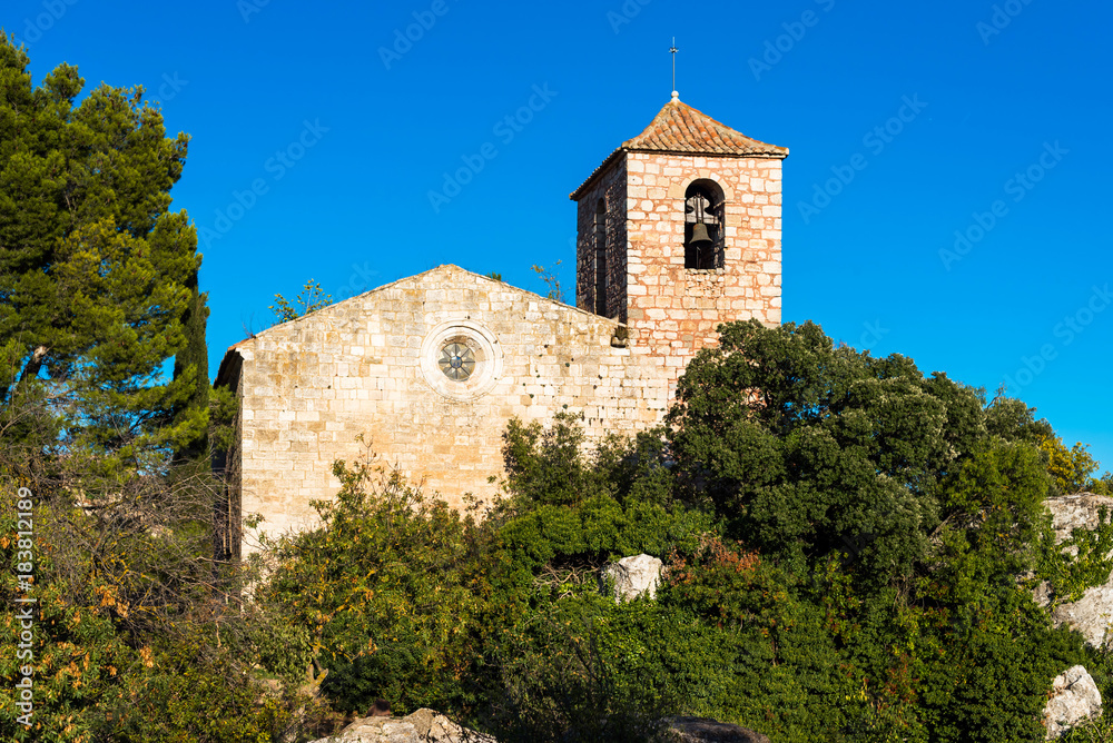 View of the Romanesque church of Santa Maria de Siurana, in Siurana, Tarragona, Spain. Copy space for text. Isolated on blue background.
