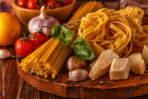 Products for cooking - pasta, tomatoes, garlic, olive oil and red wine.