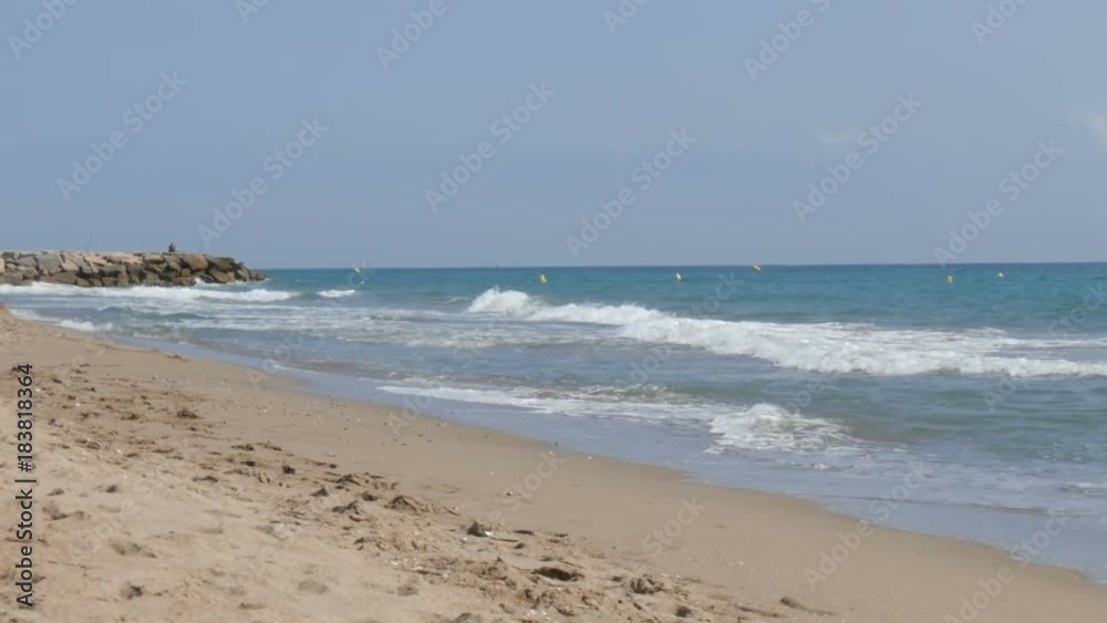 Waves of the Mediterranean Sea hit the sand on the beach in Spain Waves of the Mediterranean Sea hit the sand on the beach in Spain