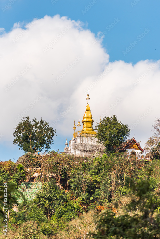 Naklejka premium View of the Buddhist temple on the mountain, Louangphabang, Laos. Copy space for text. Vertical.
