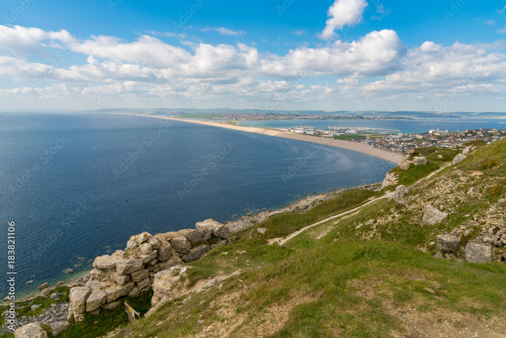 View from the South West Coast Path  towards Fortuneswell and Chesil Beach, Isle of Portland, Jurassic Coast, Dorset, UK - with clouds over Weymouth in the background