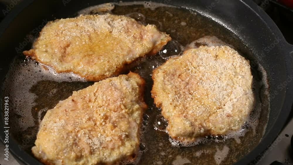 Frying pork meat coated with breadcrumbs in a pan Frying pork meat coated with breadcrumbs in a pan