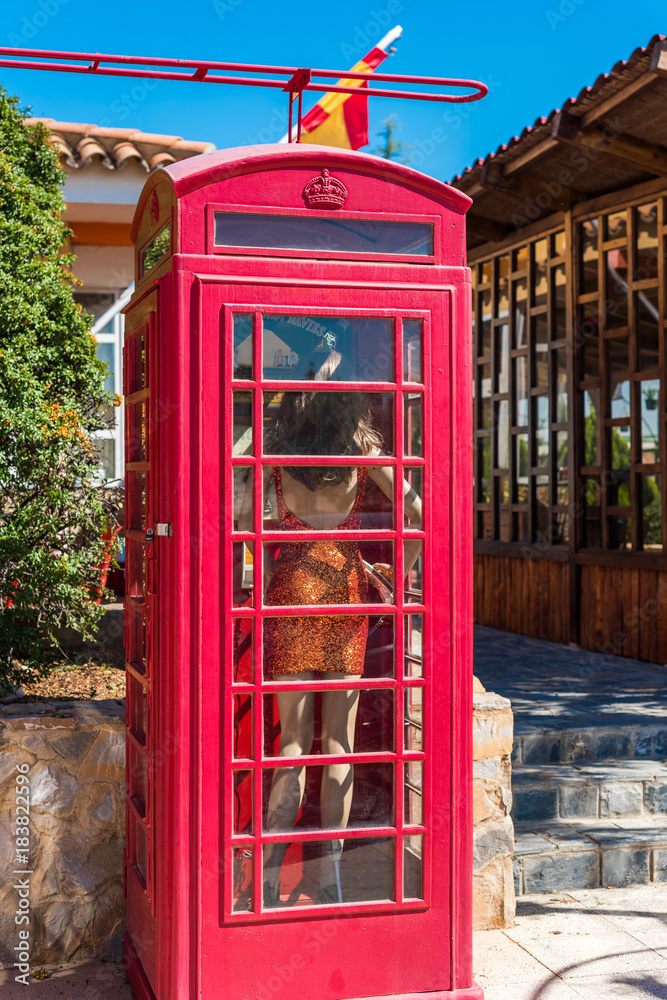Fototapeta premium View of the English telephone booth in province Guadalajara, Spain. Copy space for text. Vertical.