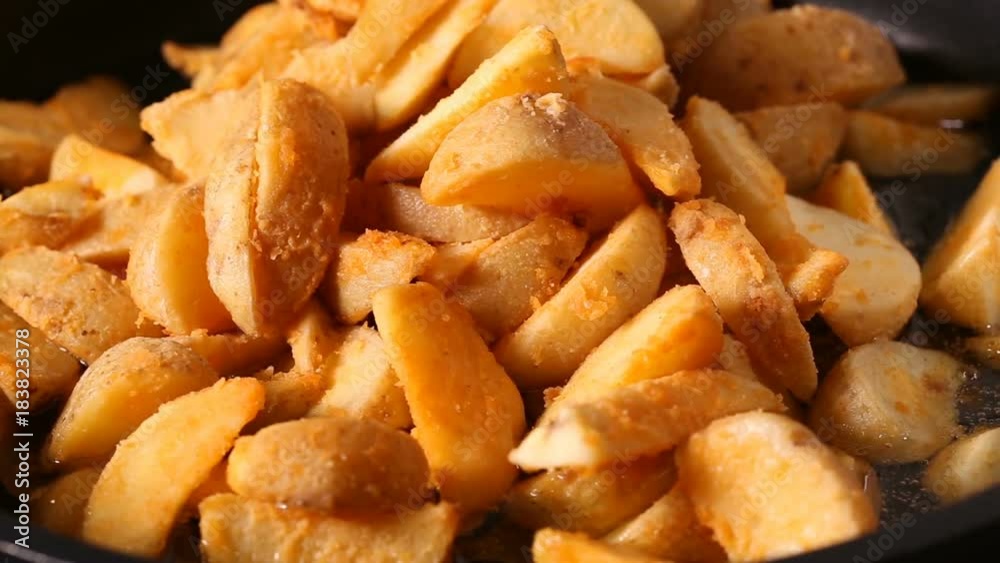 Frozen wedges potato frying in hot boiling oil Frozen wedges potato frying in hot boiling oil
