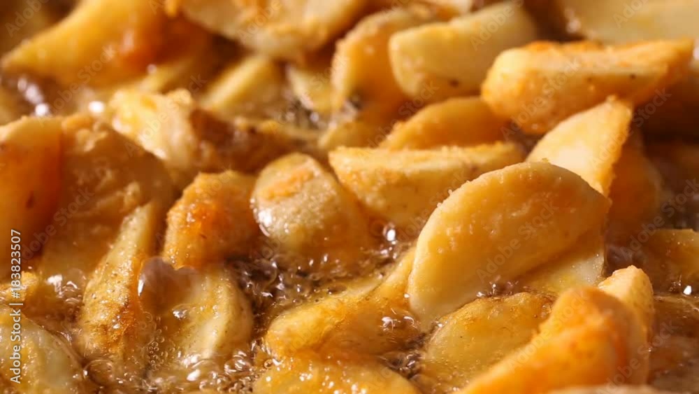 Golden fried potato wedges frying in hot boiling oil Golden fried potato wedges frying in hot boiling oil
