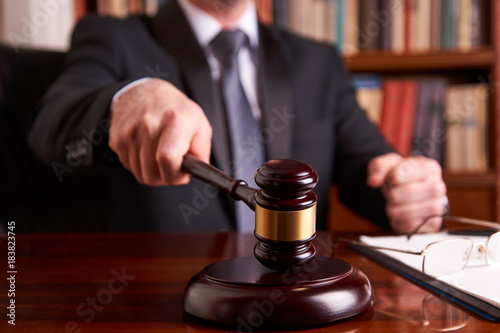 Male judge in a courtroom striking the gavel 