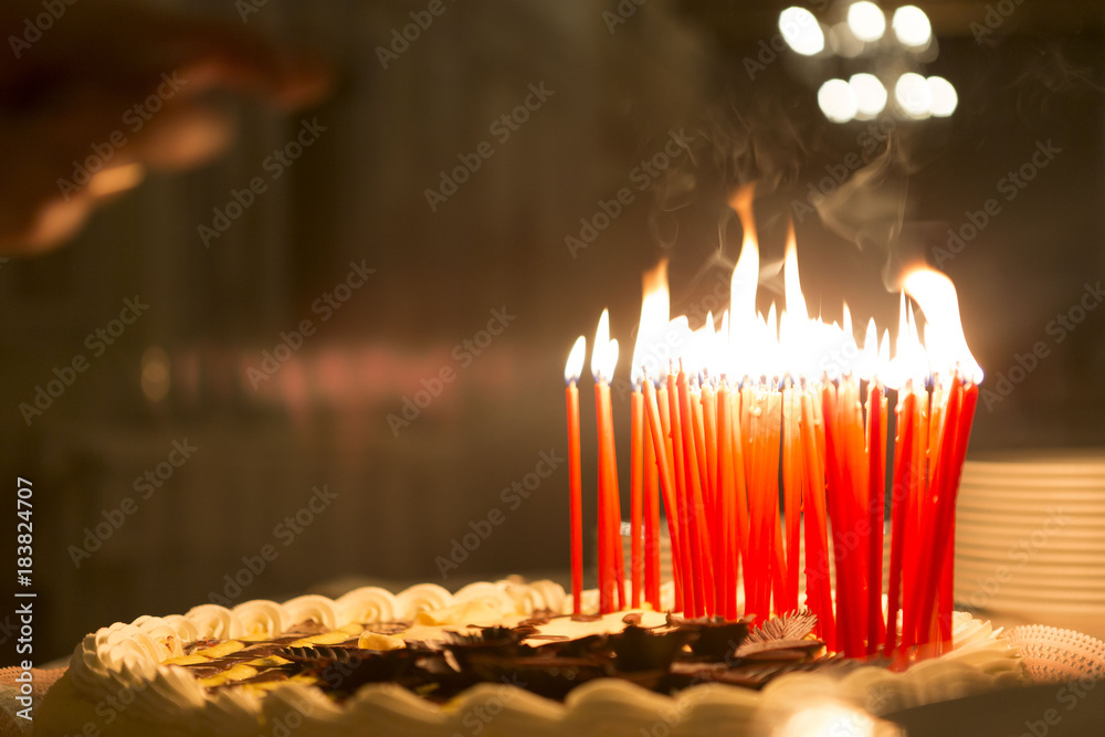 Candles lit on top of a birthday cake, background is a dark room Stock ...