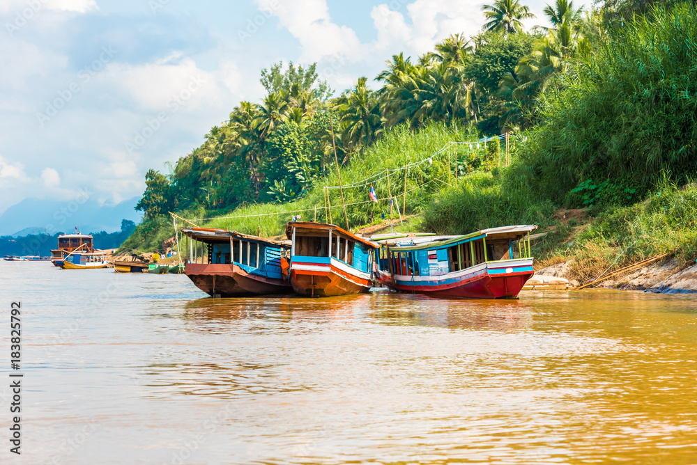 Boats near the bank of the river Nam Khan in Louangphabang, Laos. Copy space for text. Boats near the bank of the river Nam Khan in Louangphabang, Laos. Copy space for text.