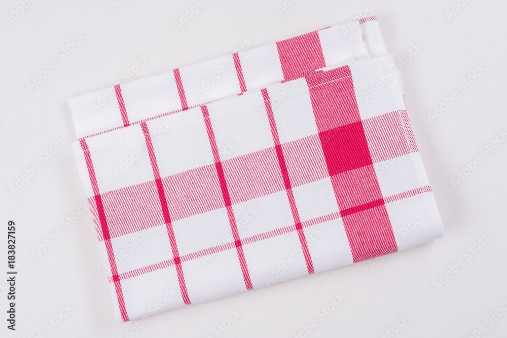 Background for product. Checked tablecloth in a red and white cage on white surface, view from above.