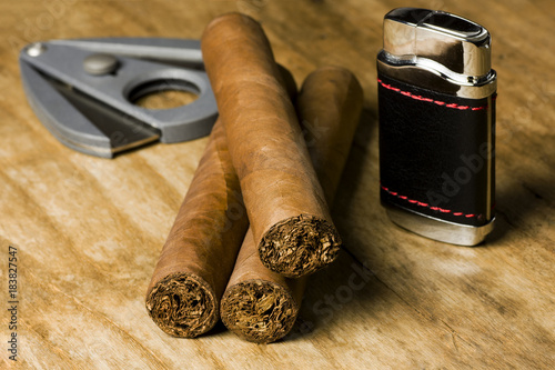 cigars with lighter and cutter on an wooden board photo