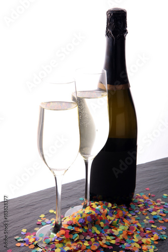 New Year concept with champagne in glass and bottle and confetti