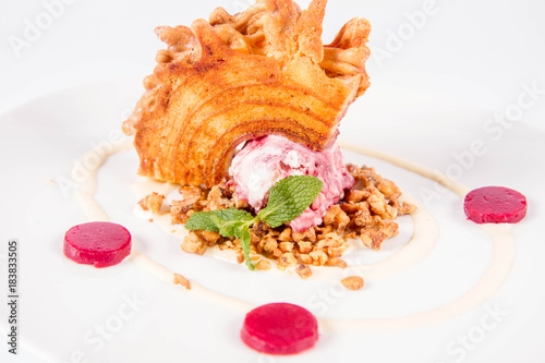 Polish-Lithuanian traditional spit cake ('tree cake') -sekacz (polish) or sakotis (lithuanian) with ice-cream, roasted nuts and raspberry jelly decorated wtih fresh mint photo