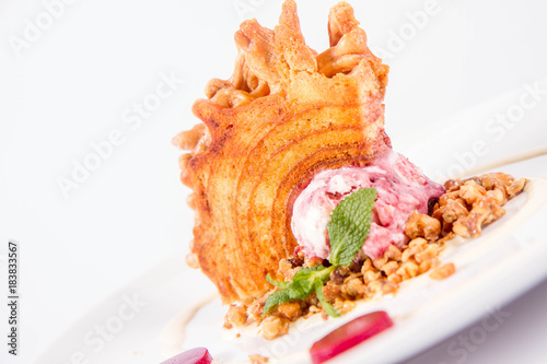 Polish-Lithuanian traditional spit cake ('tree cake') -sekacz (polish) or sakotis (lithuanian) with ice-cream, roasted nuts and raspberry jelly decorated wtih fresh mint photo