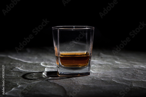 glass of cognac on a table close-up of a black background
