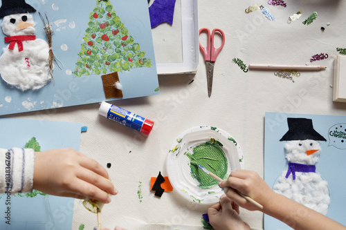 Hands of a 10 year old girl doing a Christmas craft.