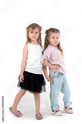 two girls the blonde in a shirt and jeans on wite background
