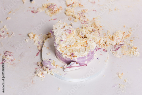 Fotografija Smashed cake on white table for first birthday. Messy pieces