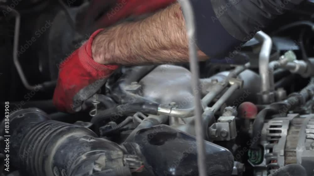 car repair in the garage. the master inspector replaces the damaged parts in the car while checking the work of the car car repair in the garage. the master inspector replaces the damaged parts in the car while checking the work of the car