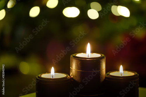 Three candles with Background Christmas Tree Lights