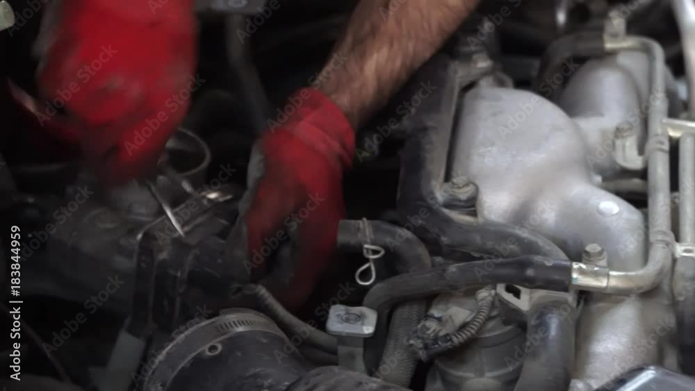 car repair in the garage. the master inspector replaces the damaged parts in the car while checking the work of the car car repair in the garage. the master inspector replaces the damaged parts in the car while checking the work of the car