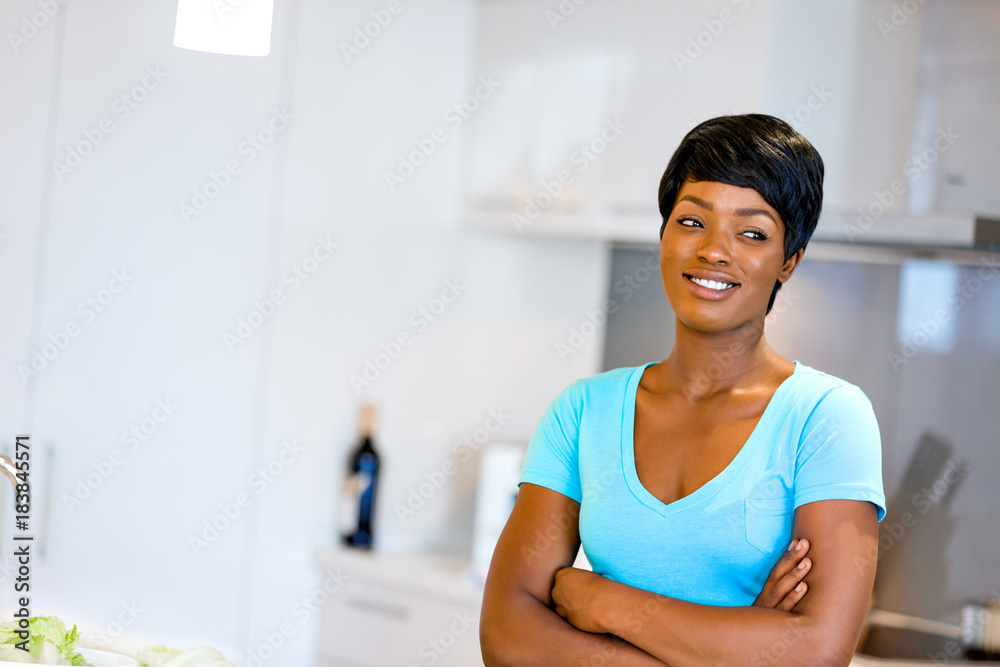 Beautiful woman standing in the kitchen and smiling Beautiful woman standing in the kitchen and smiling