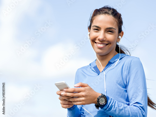 Sporty woman with earphones on the sea coast