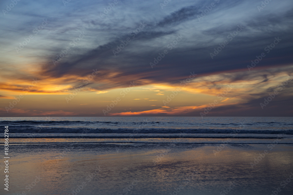 Sun setting at beach at low tide in San Diego, California