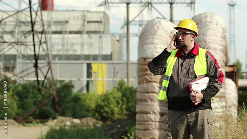 custom made wallpaper toronto digitalPowerman speaks on smartphone. Worker talks on cell phone at heat electric power station near heating main pipeline. Master builder in yellow hard hat communicates via cell phone