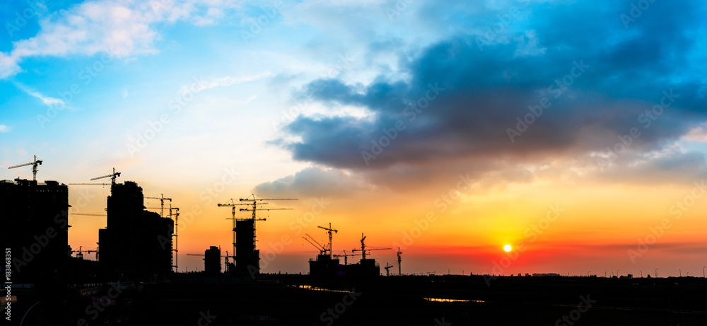 Beautiful urban construction site silhouettes at sunset,panoramic view