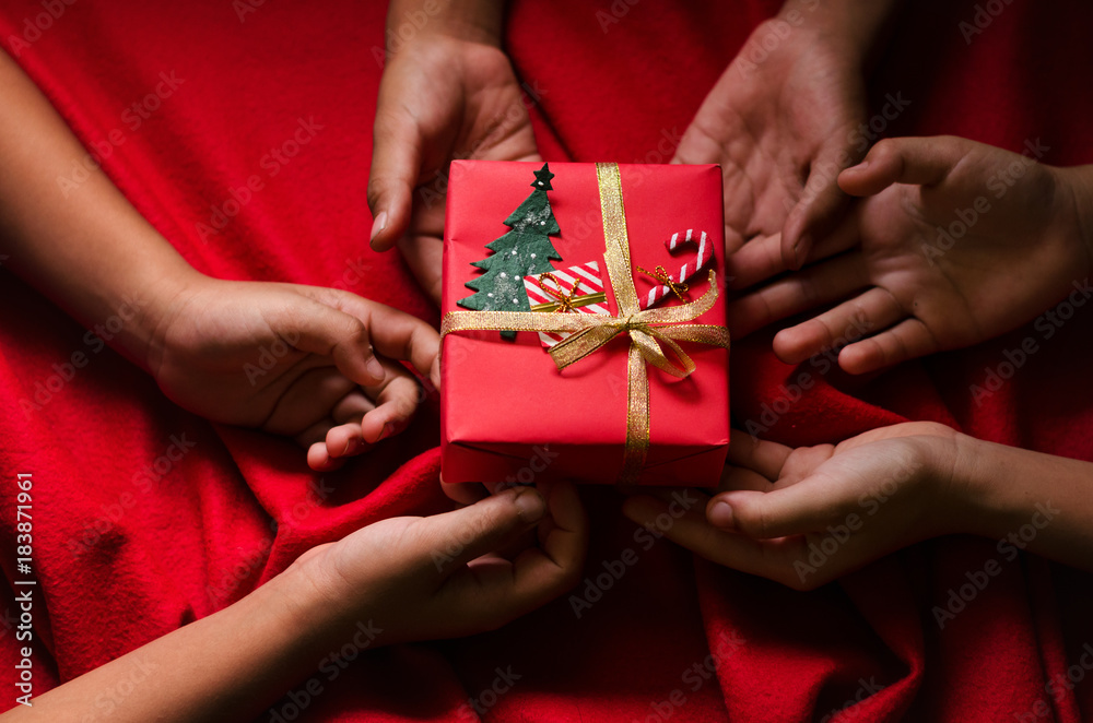 Group of Hand Kids Hold Christmas Gift Box on Red Background.