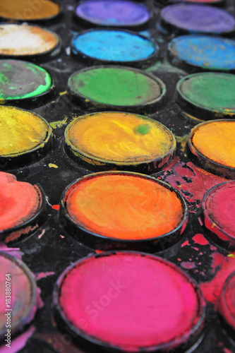 Watercolor used paint palette. Used palette can illustrate creative art work or any other concept. Colorful artsy background wallpaper.