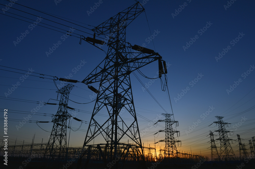 The silhouette of the evening electricity transmission pylon