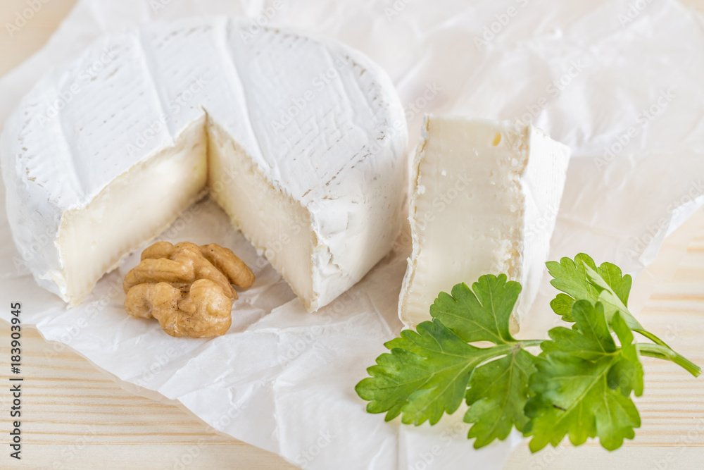 camembert, parsley and walnut on white paper camembert, parsley and walnut on white paper