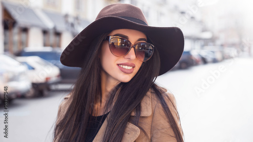 Outdoor fashion portrait of a young beautiful fashionable woman wearing stylish accessories.vintage sunglasses. Female fashion, beauty and advertisement concept. Close up. Copy space for text