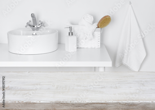 Fotografija Wooden table over blurred domestic bathroom washbowl background