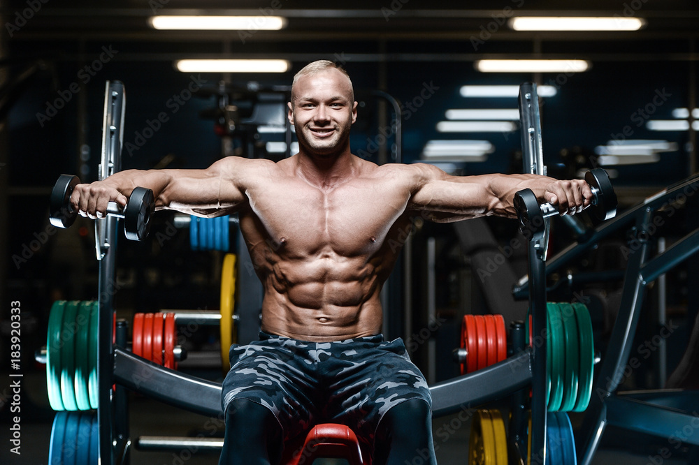 Brutal strong bodybuilder athletic men pumping up muscles with dumbbells. Brutal strong bodybuilder athletic men pumping up muscles with dumbbells.
