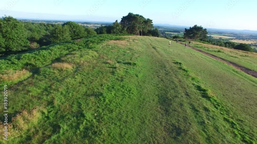 A drone shot of people in a green valley as they hangout. A drone shot of people in a green valley as they hangout.