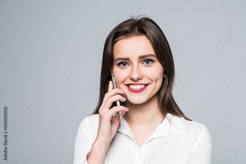 Portrait of a happy lovely woman talking on the phone and looking at camera on a white background Portrait of a happy lovely woman talking on the phone and looking at camera on a white background