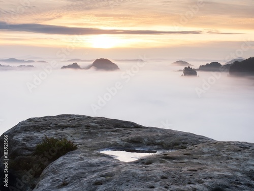 View over sharp sandstone edge into long valley full of first autumnal mist. The misty forest valley of national park i © rdonar